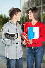 Image showing Student Giving Juice Bottle To Friend On Campus