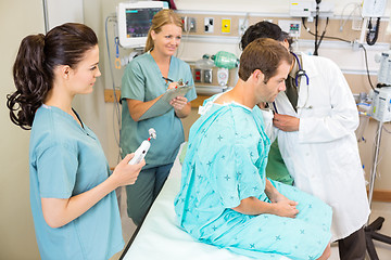 Image showing Doctor And Nurses Examining Patient