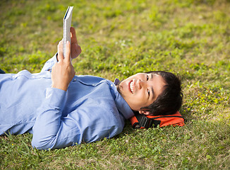 Image showing Student Holding Book While Lying On Grass At Campus