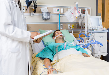 Image showing Doctor With Clipboard Examining Patient's Medical Report