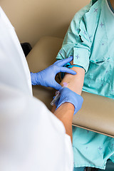 Image showing Male Doctor Drawing Blood From Patient's Arm