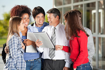 Image showing Students And Teacher With Book Standing On University Campus