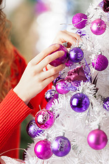 Image showing Owner Hanging Balls On Christmas Tree