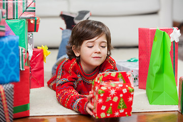 Image showing Boy With Christmas Present Lying On Floor