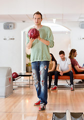 Image showing Young Man Holding Bowling Ball in Club