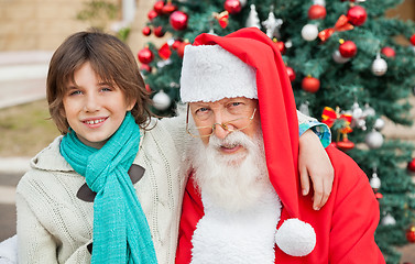 Image showing Boy With Arm Around Santa Claus Outdoors