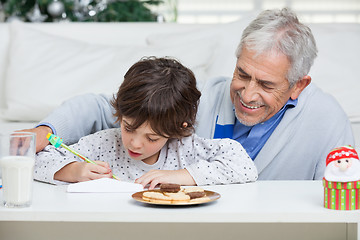 Image showing Grandfather Assisting Boy In Writing Letter To Santa Claus