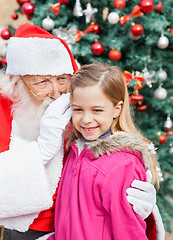 Image showing Santa Claus Whispering In Cute Girl's Ear