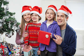 Image showing Family In Santa Hats With Christmas Present