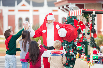 Image showing Children Giving High Five To Santa Claus