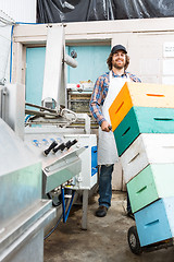 Image showing Beekeeper Holding Trolley Of Stacked Honeycomb Crates