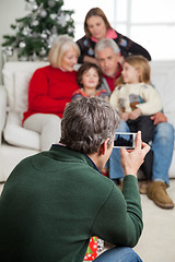 Image showing Man Photographing Family Through Smartphone