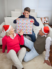 Image showing Man Holding Christmas Present While Parents Looking At Him