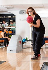 Image showing Young Woman Playing in Bowling Alley At Club