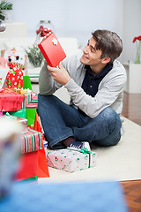 Image showing Man Looking At Christmas Present In House