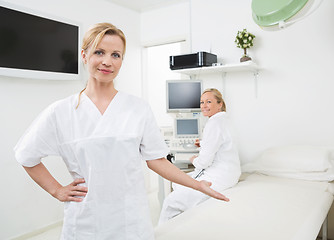 Image showing Gynecologist Gesturing With Colleague In Background