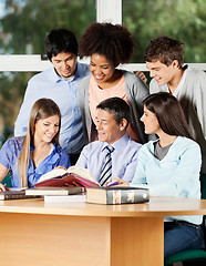 Image showing Professor Explaining Students At Desk In Classroom
