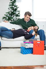 Image showing Couple With Christmas Presents Relaxing On Sofa