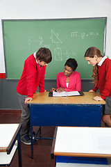 Image showing Female Teacher Teaching Teenage Students At Desk