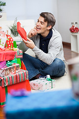 Image showing Man Looking At Christmas Gift In House