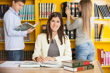 Image showing Student With Books While Friends In Background At Library