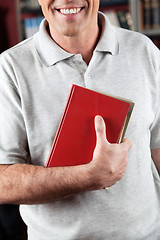 Image showing Male Librarian Holding Book In Library