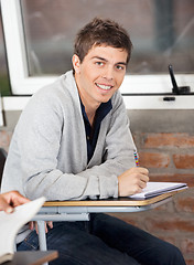 Image showing Confident Man Sitting At Desk In Classroom