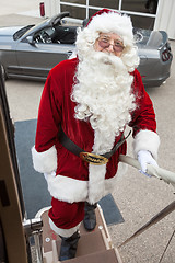 Image showing Santa Boarding Private Jet With Convertible In Background