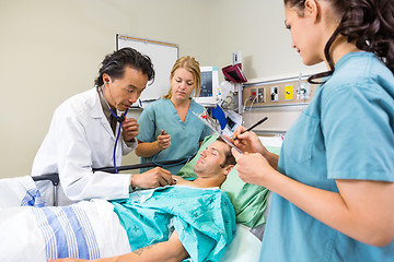 Image showing Doctor And Nurses Examining Patient