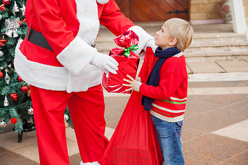Image showing Santa Claus Giving Gift To Boy