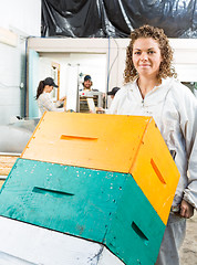 Image showing Female Beekeeper Holding Trolley Of Stacked Honeycomb Crates