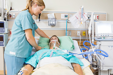 Image showing Nurse Adjusting Male Patient's Pillow