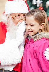 Image showing Santa Claus Whispering In Girl's Ear