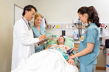 Image showing Medical Team Examining Patient In Hospital