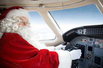 Image showing Santa Holding Control Wheel In Cockpit Of Private Jet