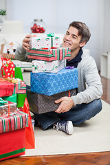 Image showing Smiling Man With Stack Of Christmas Gifts