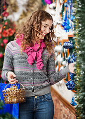 Image showing Beautiful Woman Selecting Christmas Ornaments