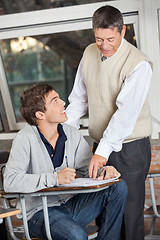 Image showing Professor Explaining Exam To Student In Classroom