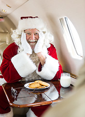 Image showing Santa With Cookies And Milk Sitting In Private Jet