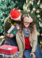 Image showing Man Surprising Woman With Christmas Presents In Store