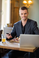 Image showing Business man With Mobilephone And Laptop In Restaurant