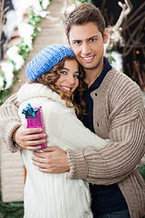 Image showing Couple With Gift Box Embracing At Christmas Store