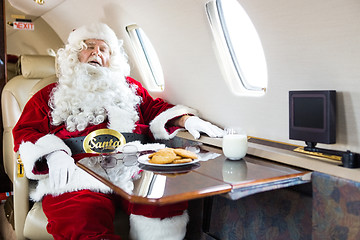 Image showing Santa Sleeping In Private Jet