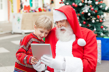 Image showing Santa Claus And Boy Using Digital Tablet