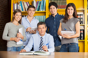 Image showing Confident Librarian With Students In College Library