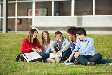 Image showing Students Sitting Together On Grass At University Campus