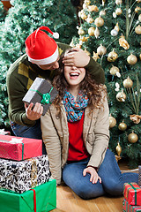 Image showing Man Surprising Woman With Christmas Gifts In Store