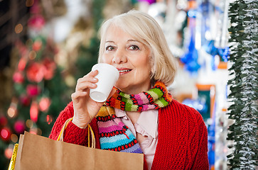 Image showing Woman With Shopping Bags Drinking Coffee At Christmas Store