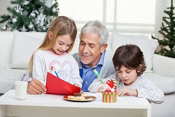 Image showing Grandfather Assisting Children In Writing Letters To Santa Claus