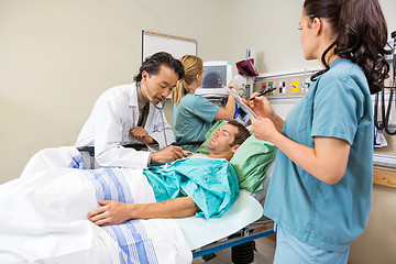 Image showing Doctor And Nurses Examining Patient In Hospital